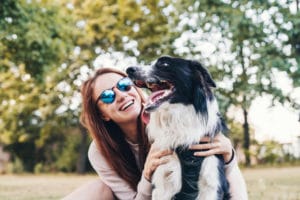 Young woman playing with a dog in the park