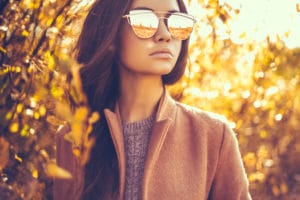 Outdoor fashion photo of young beautiful lady surrounded autumn leaves