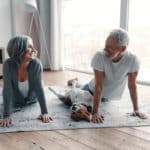 Loving senior couple in sports clothing doing yoga